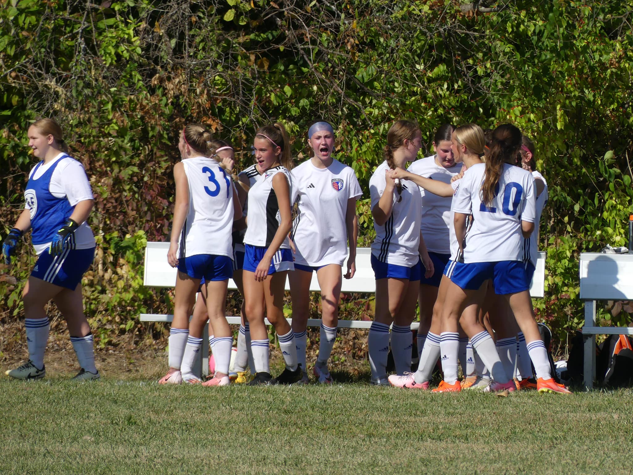 HNFC travel team players regrouping near the bench, ready to resume play