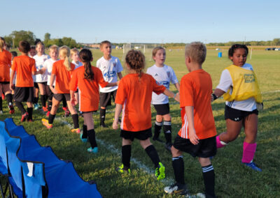 Players from two soccer teams exchanging handshakes after a match.